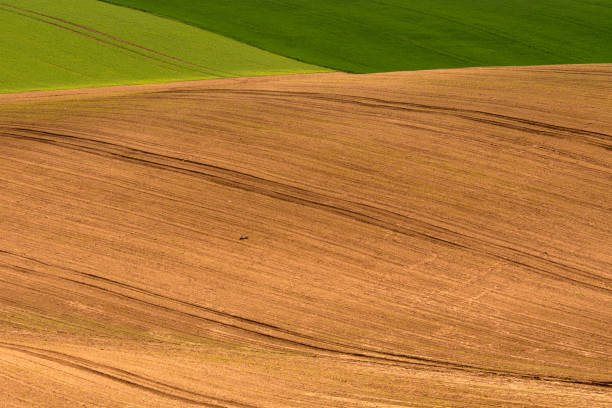 Background of brown earth. View of freshly plowed field ready for seeding and planting in spring.