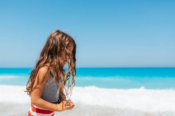 istock Girl playing on the beach on her summer vacation 2112914835
