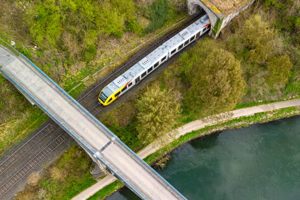 a train that is on the tracks by some water and a bridge