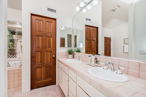 Spacious bathroom with double sinks, mirror, and bathtub