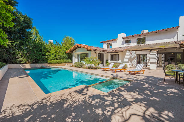 istock a pool and some chairs near a house with a patio 2112937777