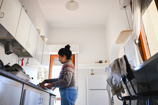Low angle view of a woman washing dishes.
