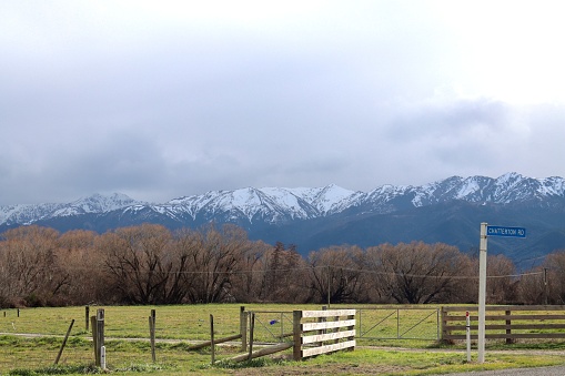 Rural view over rural paddocks looking at snow covered mountain range