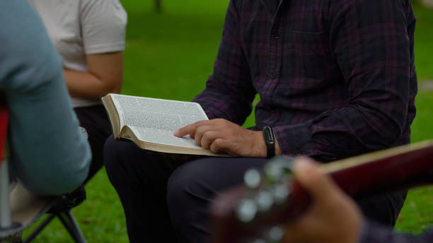 ludzie czytają pismo święte. i zaprzyjaźnia się grając na gitarze, księgi biblijne, koncepcje chrześcijaństwa. - credo zdjęcia i obrazy z banku zdjęć