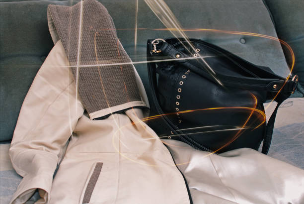 A woman's leather jacket and bag stayed on the couch.