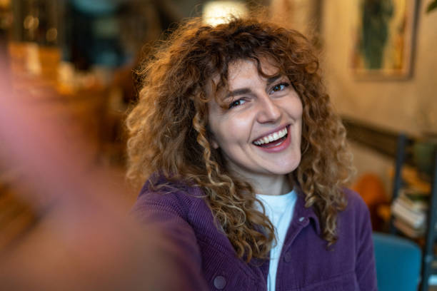 Beautiful young woman making selfie at coffee shop