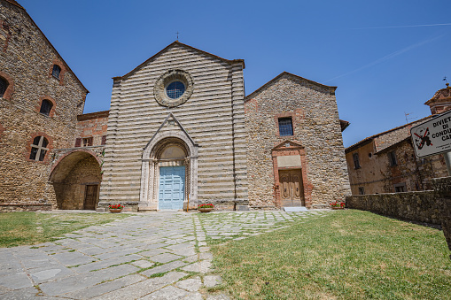 Lucignano, Italy - 23 of May 2022: Walking streets of small historic town Lucignano. View of San Francesco church facade.