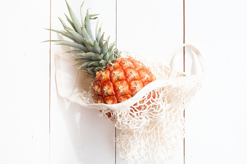 pinapple on white wooden table in bag