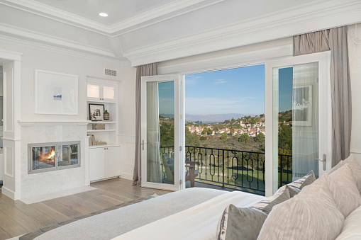 A master bedroom with expansive windows showcasing a beautiful view