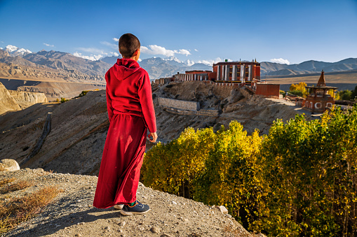 Lamayuru, India - July 14, 2012: Two peaceful monks talk and rest during a break at the holy ceremony in the Buddhist monastery of Lamayuru, Ladakh, India.