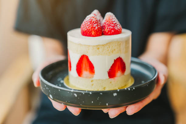 istock A woman's hand is holding a strawberry shortcake. 2113158449