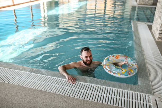 istock Smiling Male With Inflatable Swimming Ring Smiling While Spending Day In pool 2113170619