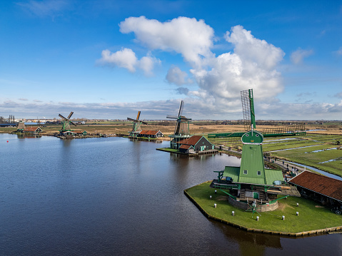 Netherlands - Beautiful old windmills near Amsterdam on the shore of a lake from drone view