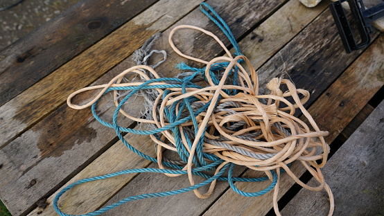 A closeup shot of messy rope and string entangled on a wooden surface
