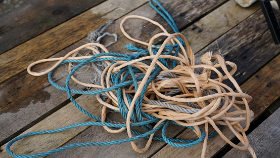 A closeup shot of messy rope and string entangled on a wooden surface