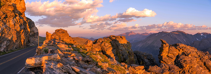 A panoramic sunset view of Trail Ridge Road at Rock Cut, with Longs Peak (14,255 ft) towering in background, on a calm Summer evening. Rocky Mountain National Park, Colorado, USA.