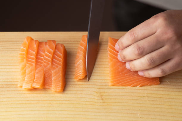 istock sushi chef cutting salmon sashimi 2113315158
