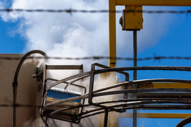 Low angle view of tomato sauce filled tin can, rolling down a rail conveyer through a steam cleaner sanitizer.