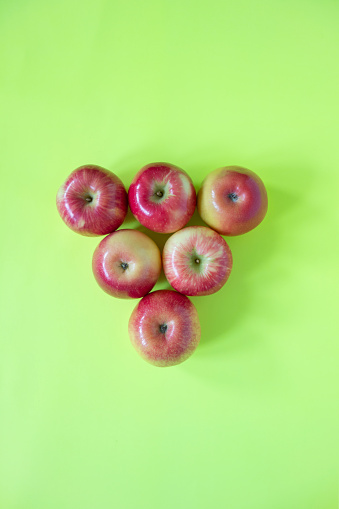 Group of fresh organic red apples on green background