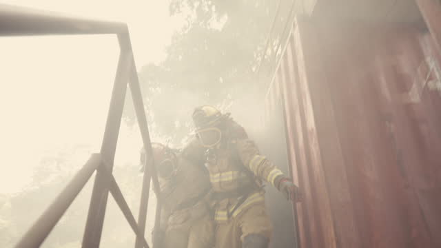 An unconscious firefighter is rescued from a burning factory.