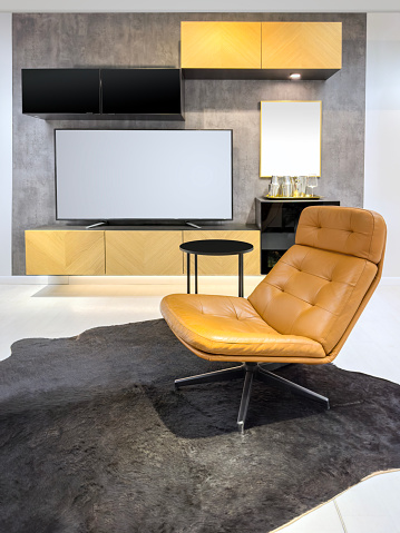 Chic leather armchair in front of media center with tv unit