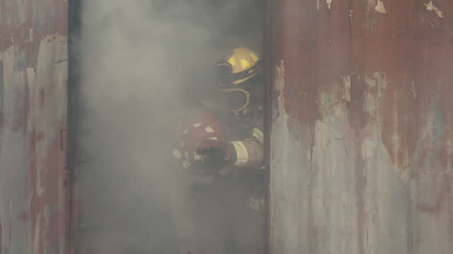An unconscious firefighter is rescued from a burning factory.