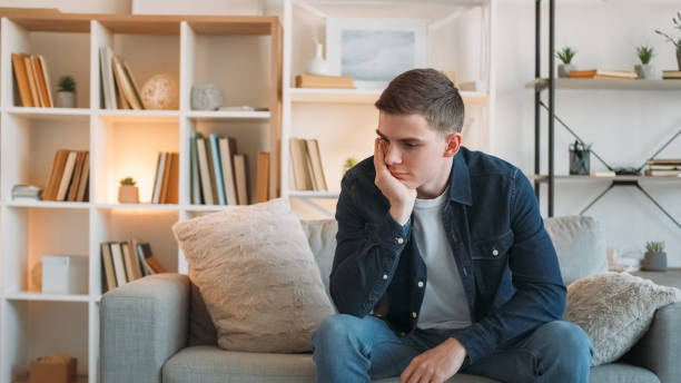 istock Frustration depression bad mood man couch home 2113345166