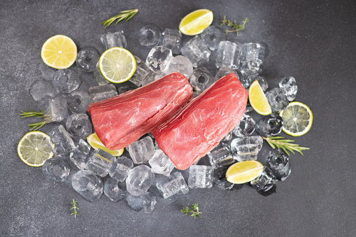 Fresh cooled tuna Fish steak lays on ice.