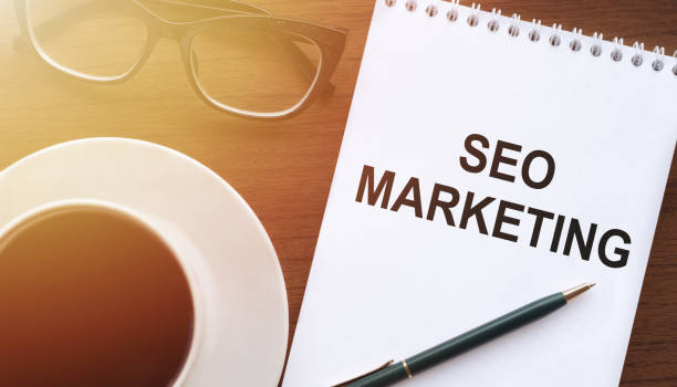 istock SEO Search Engine Optimization text in notebook on the desk in sunlight next to glasses, a cup of coffee and a pen 2113351186