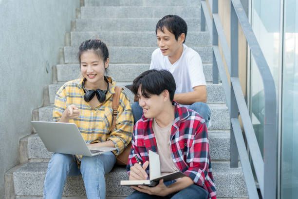 istock Group Asian student meeting team for work project. team happy study online. Read book in college campus. Group on international Asia University. Education, study, school, college, graduation 2113377159