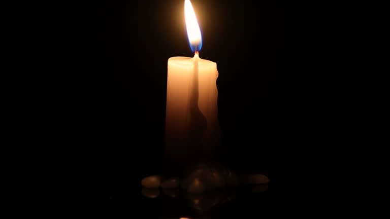 Burning White Candle with Black Background Copyspace