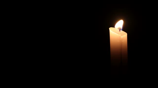 Burning White Candle with Black Background Copyspace