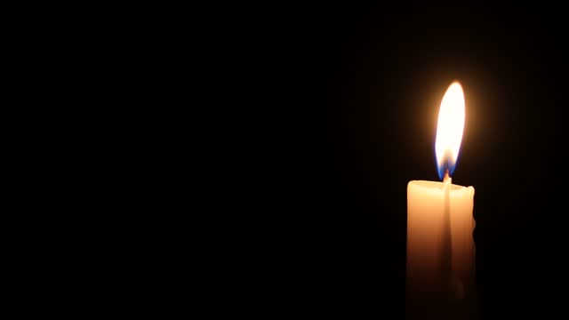 Burning White Candle with Black Background Copyspace