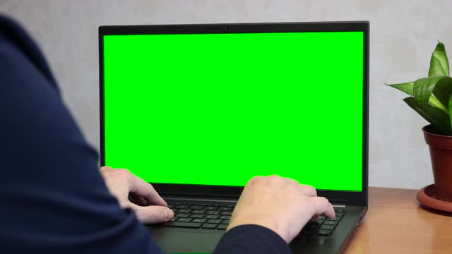 Persona user press keyboard on laptop with green screen chromakey mockup