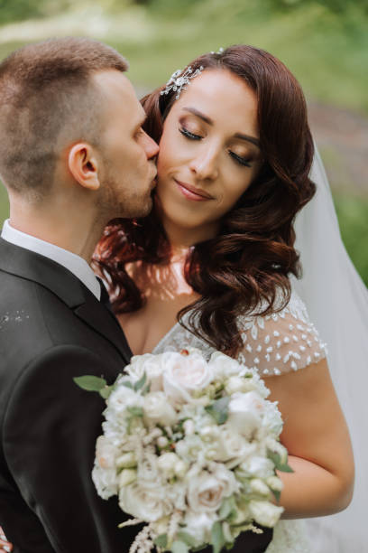 istock Wedding. Love and couple in garden for wedding. Celebrating the ceremony and commitment. Save the date. Trust. The groom embraces the bride. Tender kisses. Couple in love. Wedding portrait 2113469549