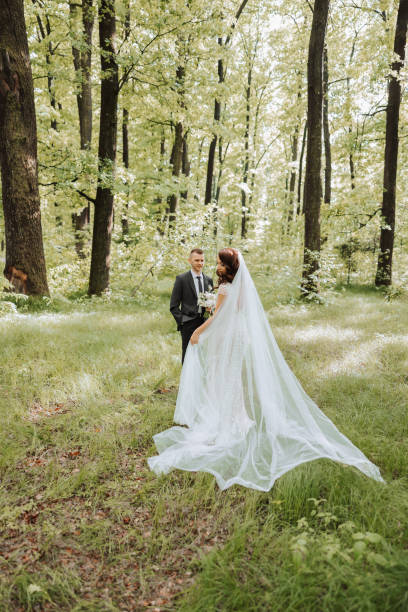 istock Wedding. Love and couple in garden for wedding. Celebrating the ceremony and commitment. Save the date. Trust. The groom embraces the bride against the background of a green background. Couple in love 2113469912