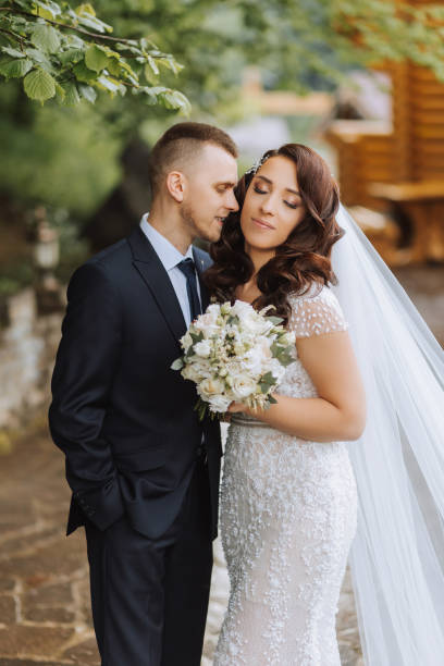 istock Wedding. Love and couple in garden for wedding. Celebrating the ceremony and commitment. Save the date. Trust. The groom embraces the bride. Tender kisses. Couple in love. Wedding portrait 2113470071