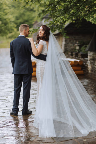 istock Wedding. Love and couple in garden for wedding. Celebrating the ceremony and commitment. Save the date. Trust. The groom embraces the bride. Tender kisses. Couple in love. Rear view. 2113470099