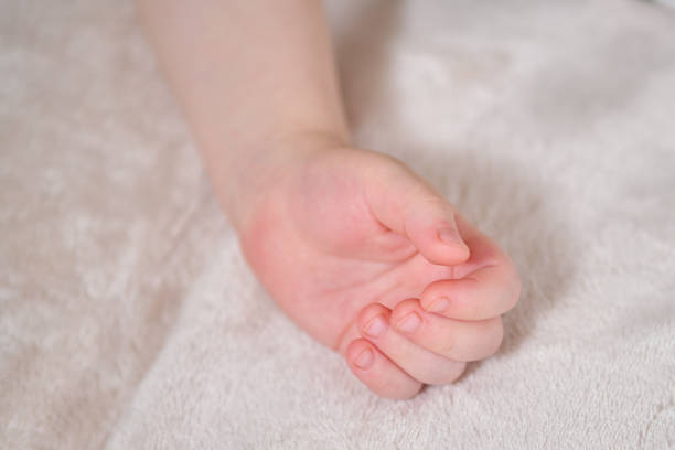 An Asian woman is holding hands with her young nephew at home