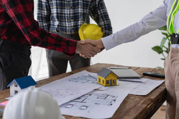 istock Close-up photo of architect and construction engineer holding hands while working for teamwork and cooperation concept after completing agreement in office construction site with house plans on table 2113492312