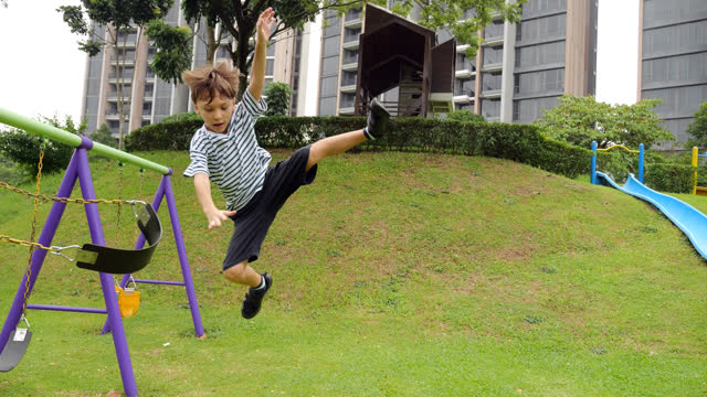 Boy demonstrates his agility on playground, flying in air as he jumps from swing