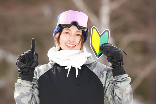 A woman in snowboarding wear with a beginner mark