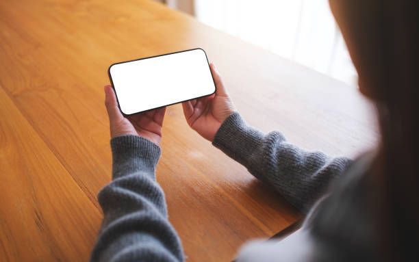 istock Mockup image of a woman holding mobile phone with blank desktop screen 2113713613