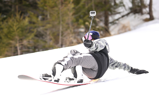 Female snowboarder using an action camera