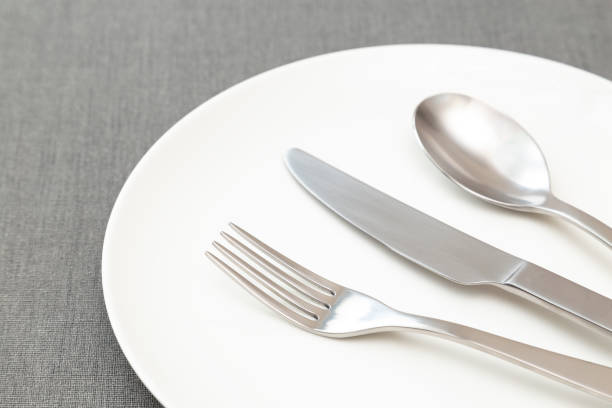 istock White plates and cutlery on the placemat. 2113727005