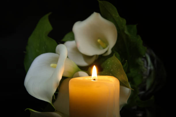 istock Burning wax candle in close up and white calla lily 2113736381