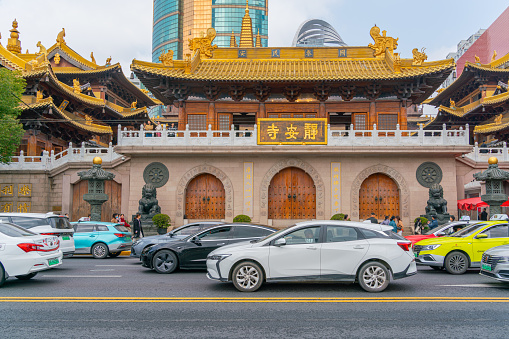 Shanghai, China - March March 15th 2024: view of Jing'an Temple and traffic , Jingan Temple is a Buddhist temple on the West Nanjing Road in Shanghai, China. Jingan District, where it is located, is named after the temple.