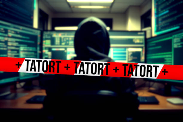A hacker in front of the computer and barrier tape crime scene