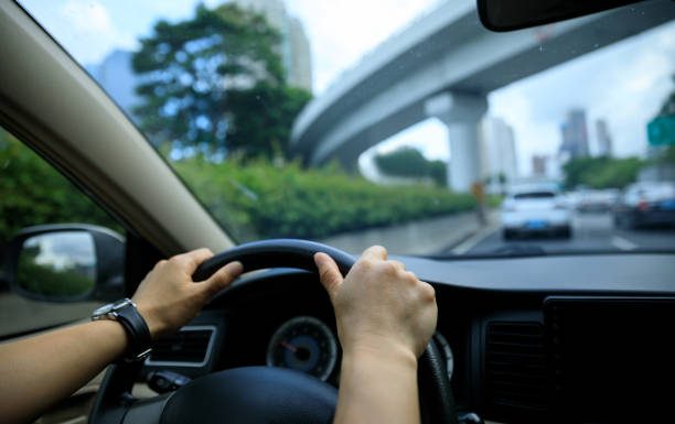istock People driving car on city road 2113815341