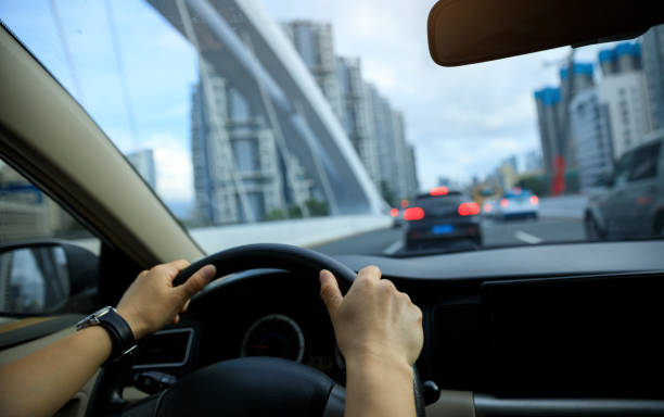 istock People driving car on city road 2113816358